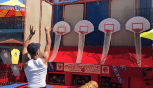 a person playing a basketball hoop carnival game